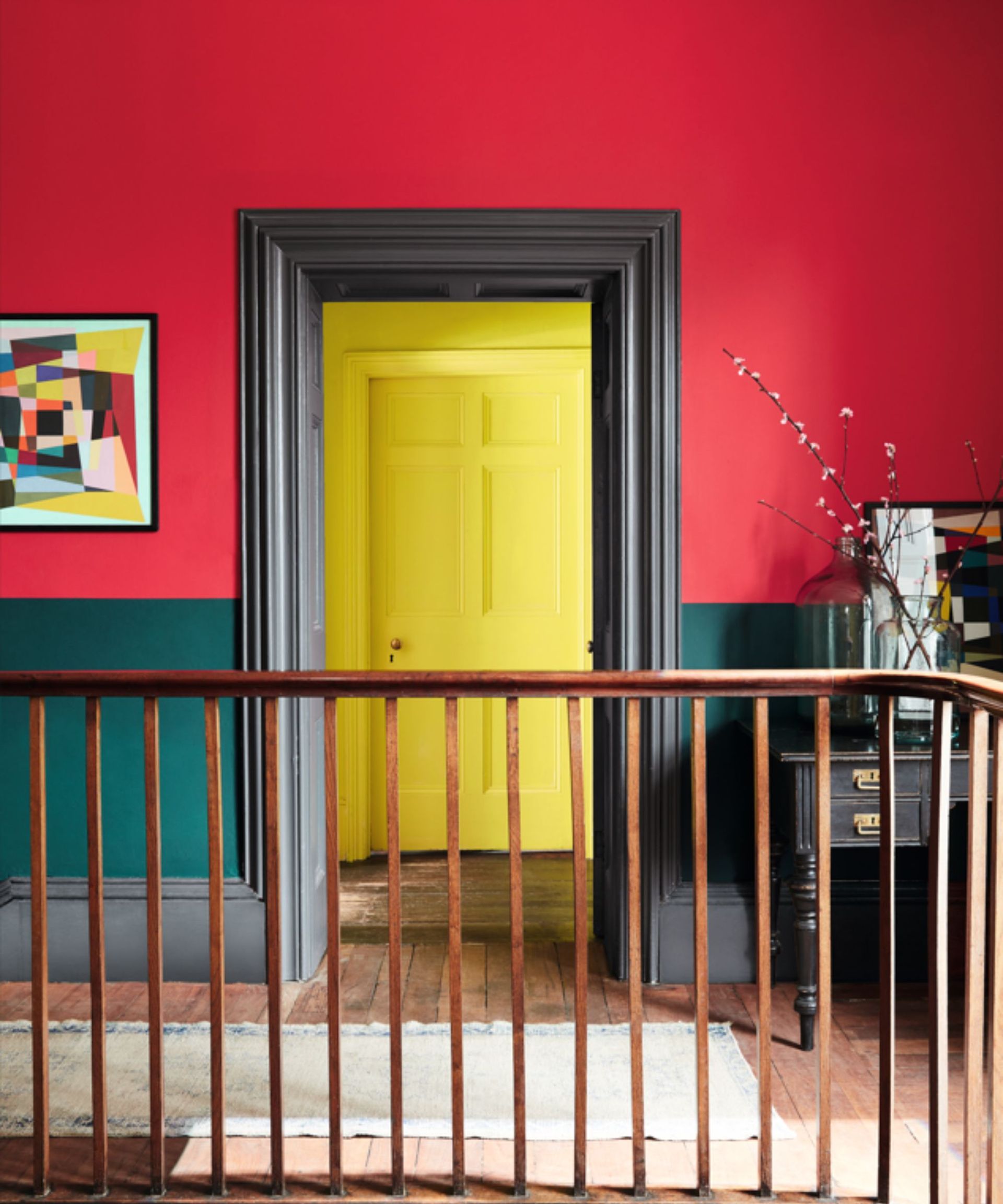 bright red hallway with black trim, leading into room with bright yellow door