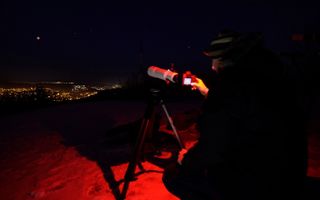 Amateur astronomers observe and take pictures of the super blood moon lunar eclipse at Harmashatarhegy above the Hungarian capital Budapest on Jan. 21, 2019.
