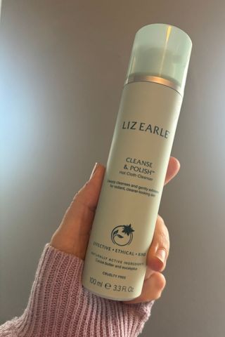 a hand holding liz earle cleanse and polish