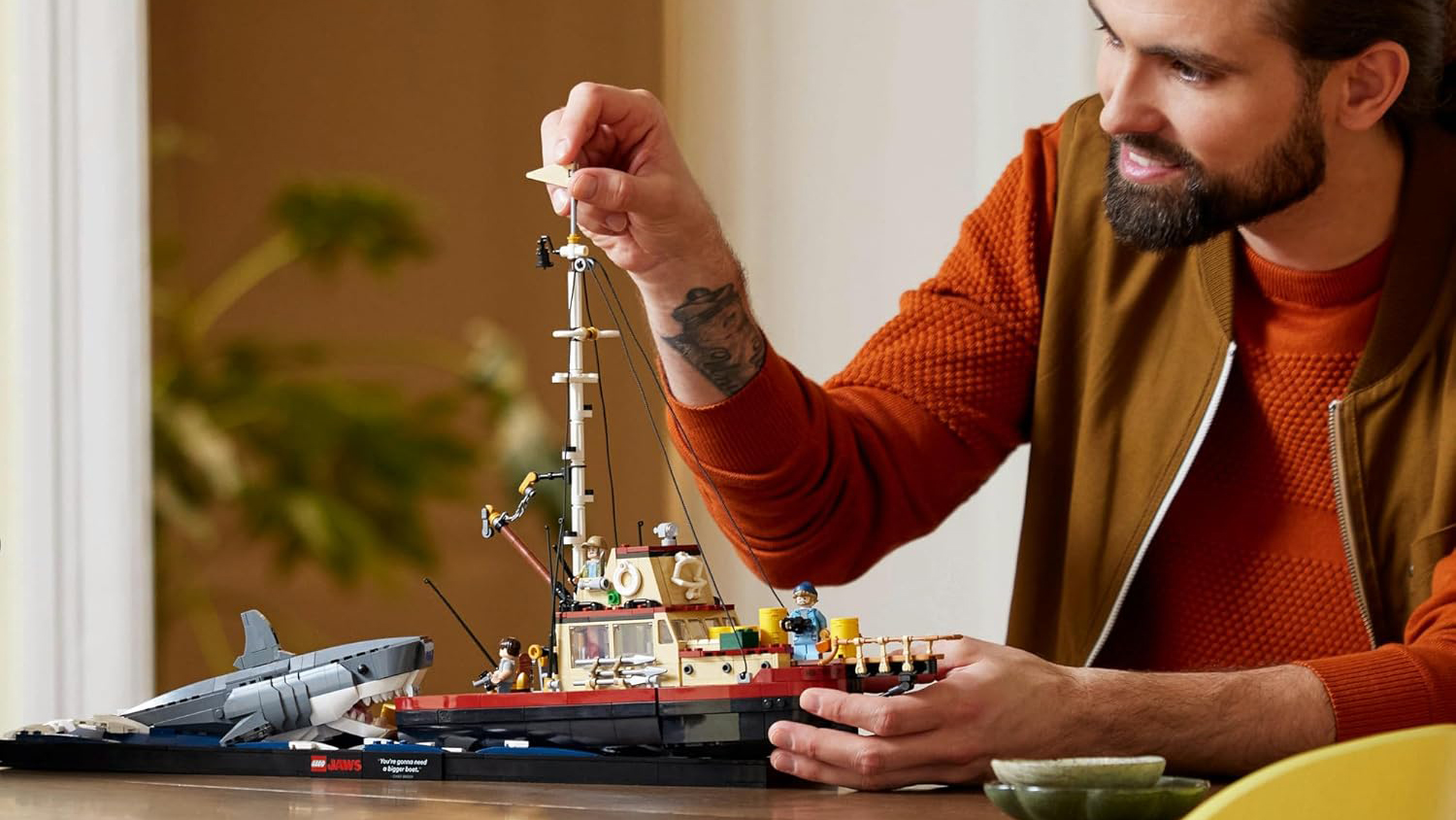 A man playing with the Lego Ideas Jaws set