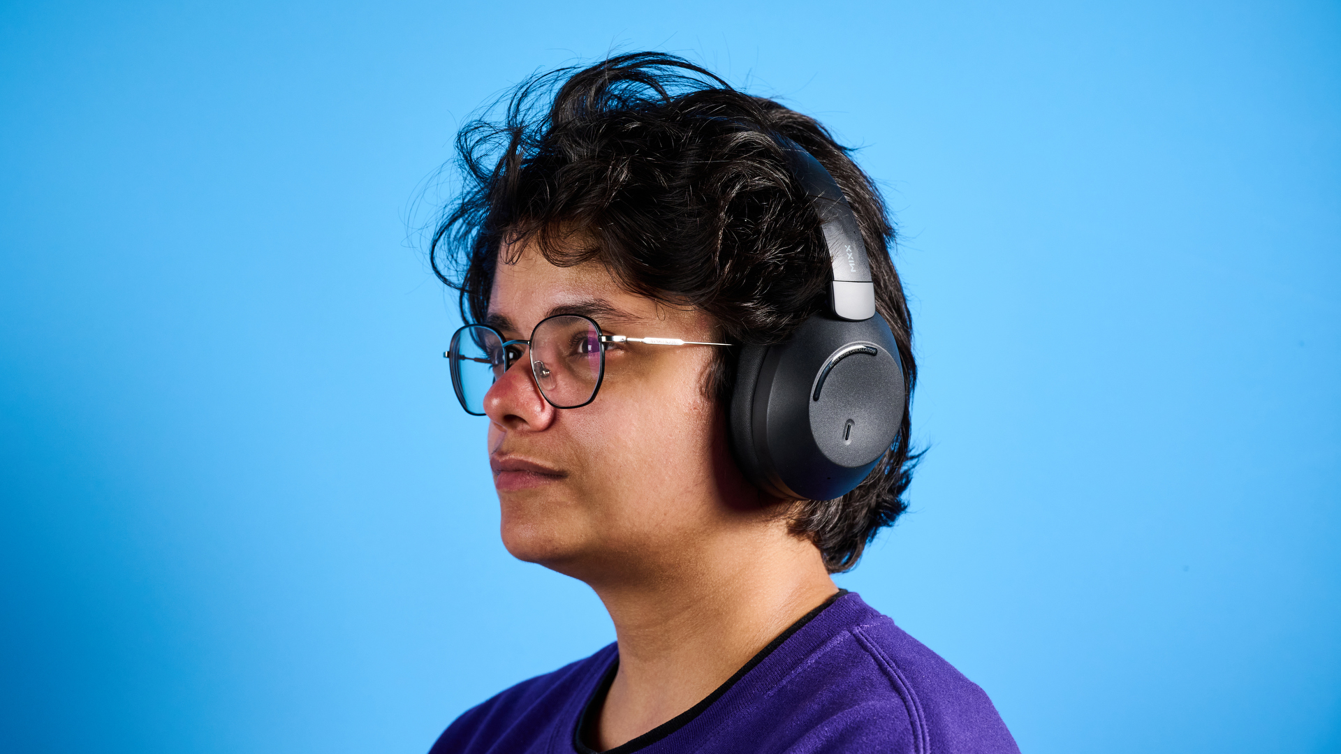 the mixx streamq c4 headphones in black with a blue background showing the soft cups and buttons controls
