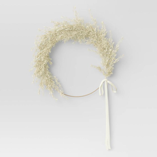 A white pampas grass wreath with a bow
