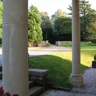 house entrance with columns and front yard lawn