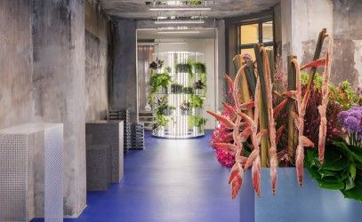 Flower show with concrete walls, blue floor and industrial lighting