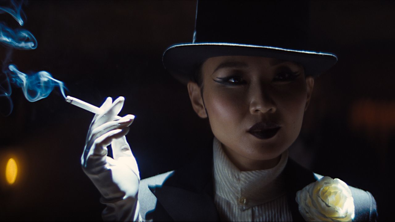 Li Jun Li's Lady Fay Zhu smokes a cigarette at night in Damien Chazelle's Babylon film