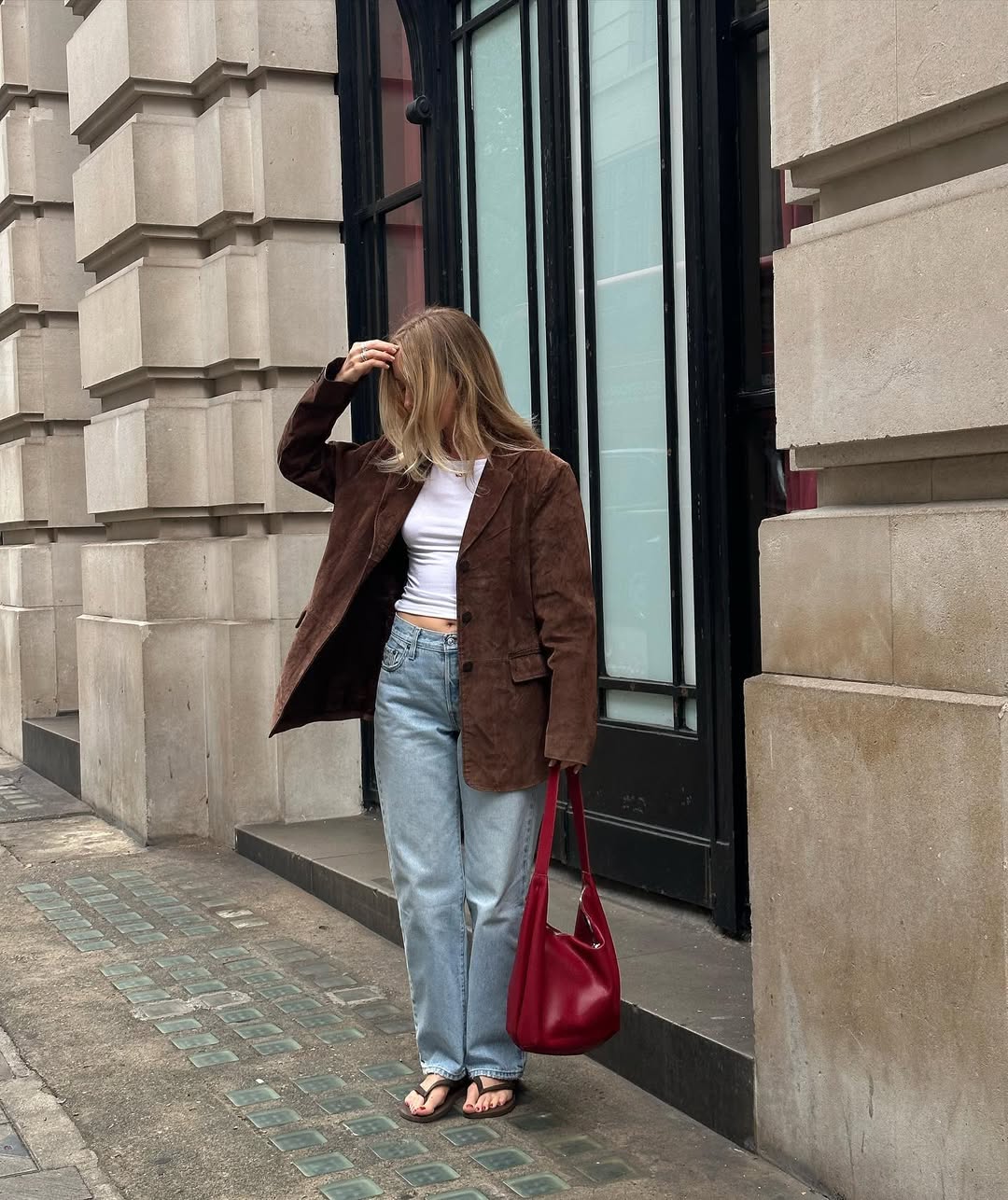 @chloekathbutler wears barrel-leg jeans, white tee, suede blazer, brown flip-flops and red leather tote