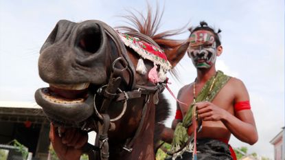 A Cambodian resident performs during a parade at Pring Ka-Ek village on the outskirts of Phnom Penh, Cambodia