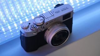 Fujifilm X100VI camera in front of a purple blue light