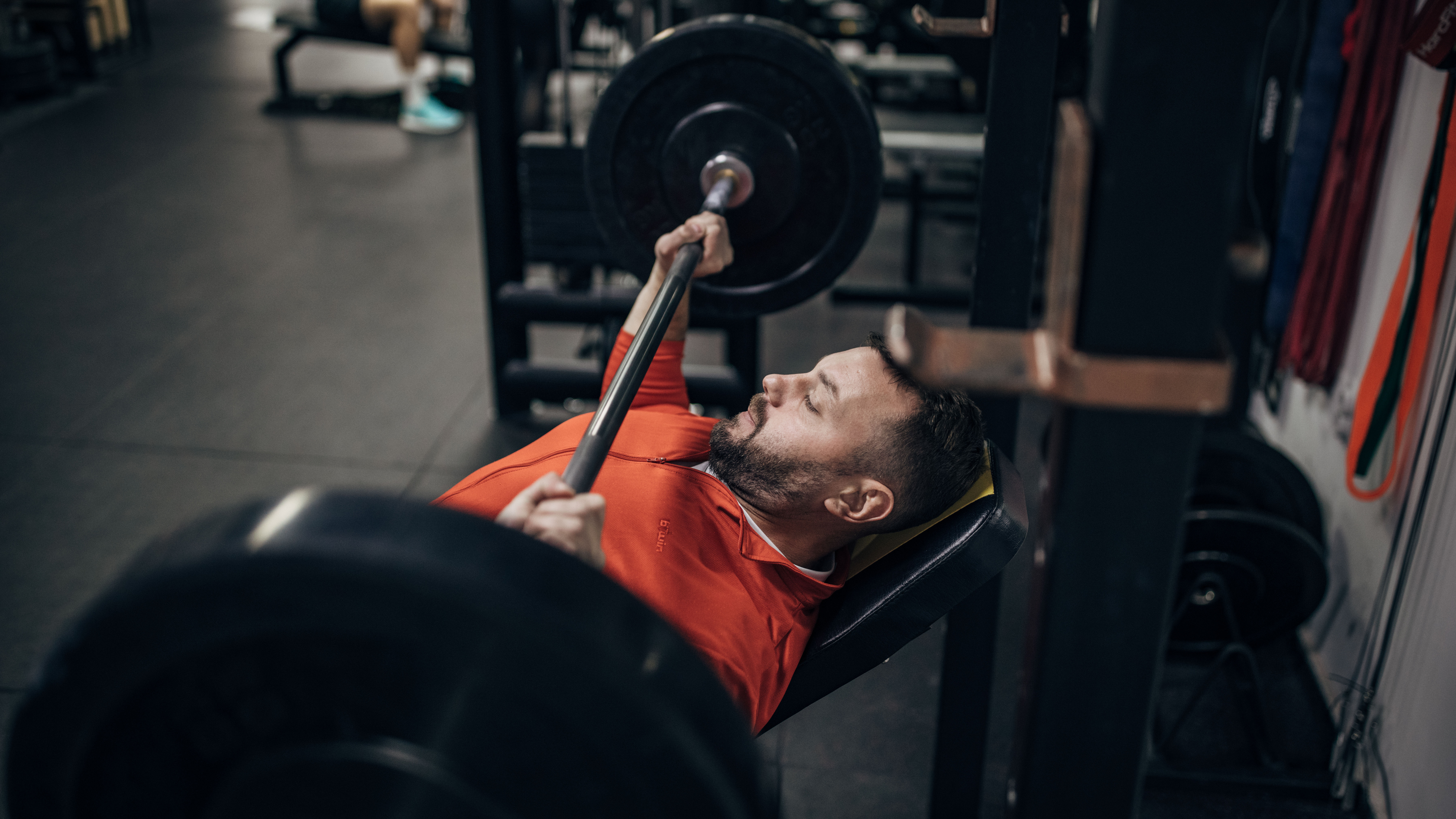 man doing bench press in gym