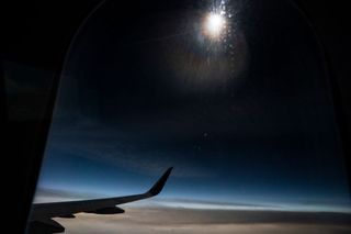 The solar eclipse seen though the window of a Delta airline plane on Monday April 8