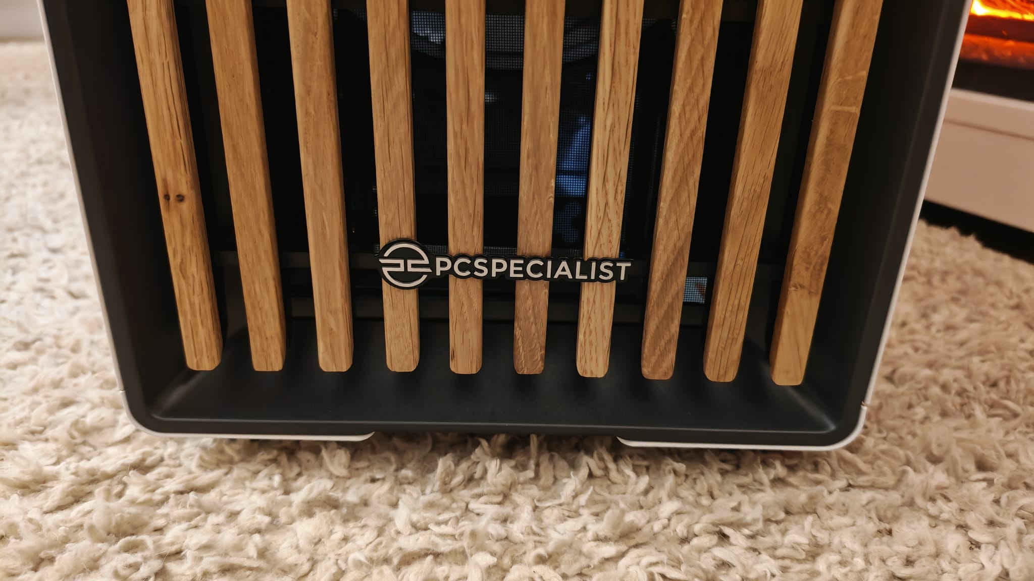 A PCSpecialist logo on the wooden panels of a Fractal Design North case