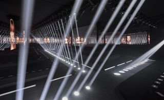 the catwalk at the Louis Vuitton Foundation houses designed by Frank Gehry included spotlights and holograms of faces