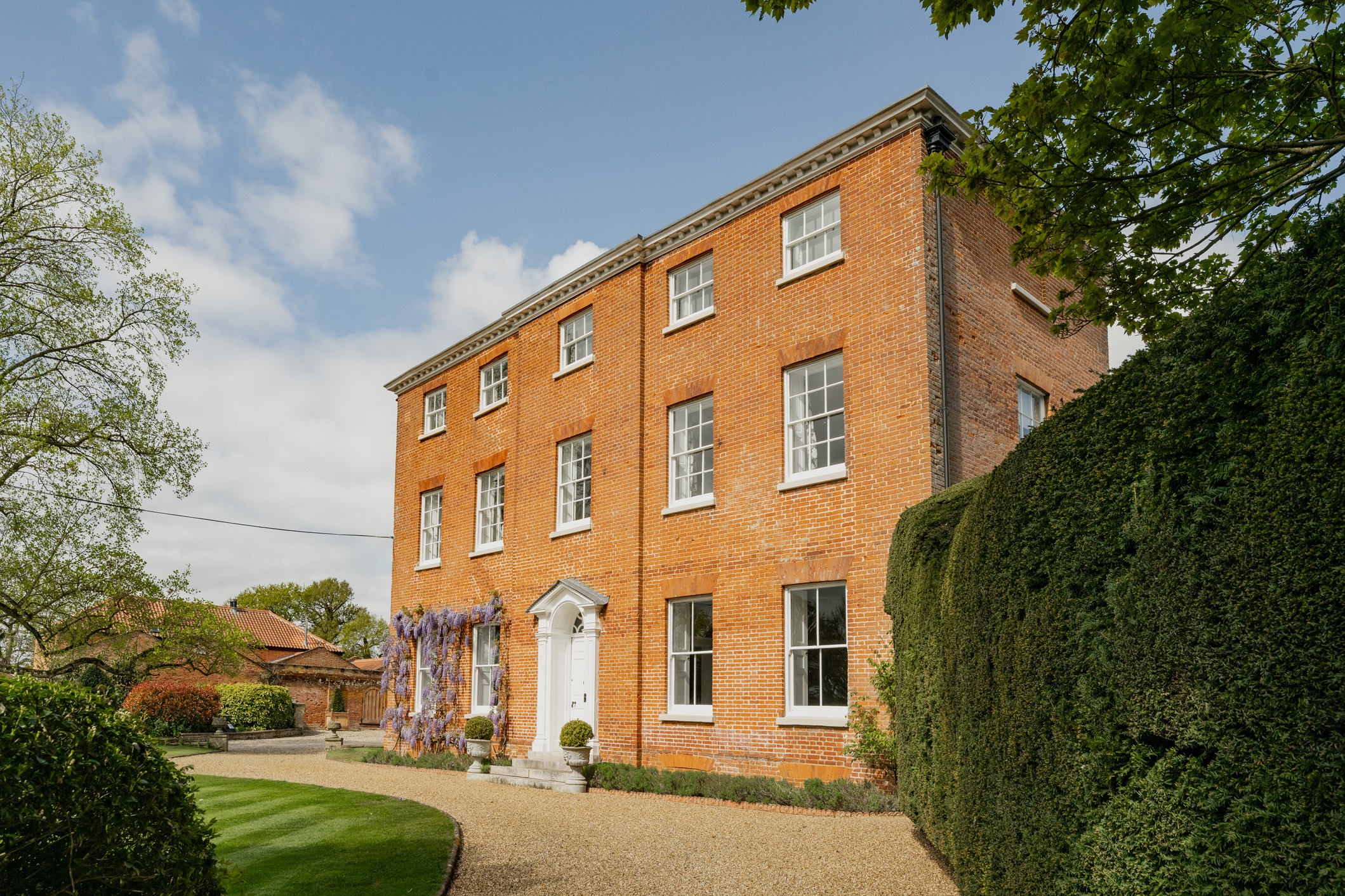 A view of the front red-brick facade of Dillington Hall