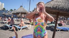 A beachgoer cheers on anti-tourist protesters in the Canary Islands, 20 October 2024