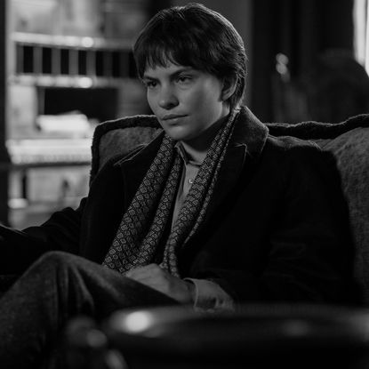 Eliot Sumner as Freddie Miles, sitting in an armchair and holding a glass, in Episode 105 of RIPLEY