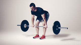 Romanian deadlift, demonstrated by a man holding a barbell just below his knees