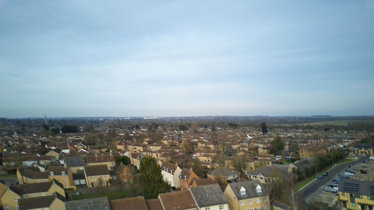 Aerial shots taken with the Veeniix V11PRO drone's camera showing houses and a skyline, roads with green surroundings and a multi-colored art display.