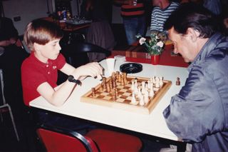 Prince William at age 11 playing chess with a homeless man at a shelter