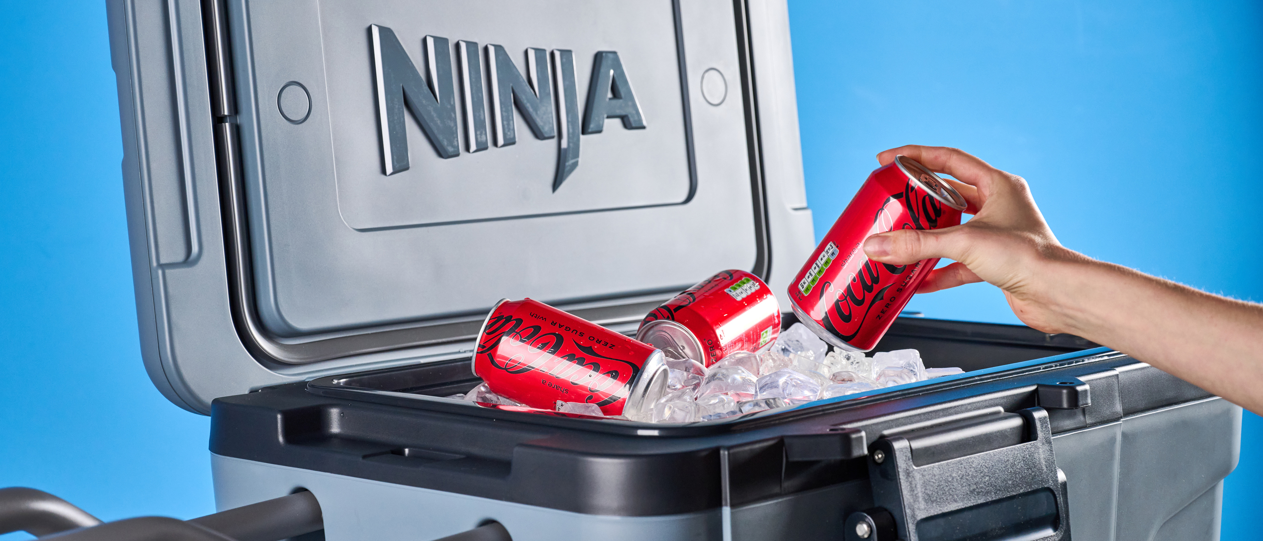 The Ninja FrostVault 45QT Wheeled Cooler photographed in front of a blue background. 