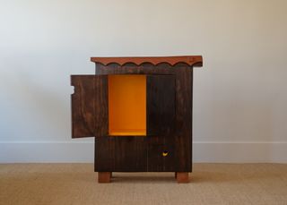 Dark wooden cabinet with orange interior