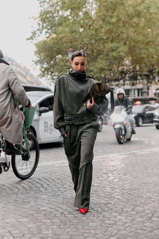 Showgoer at Paris Fashion Week wearing funnel neck coat.