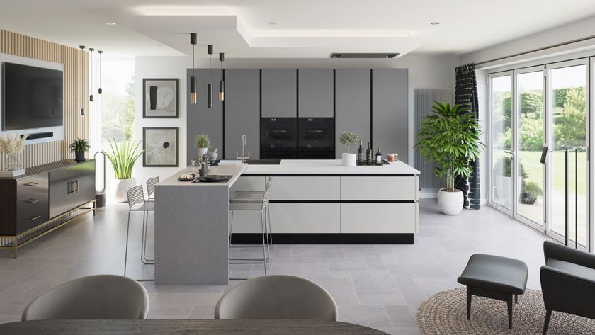 grey and white kitchen with breakfast bar extending off central island in large open plan kitchen diner with patio doors