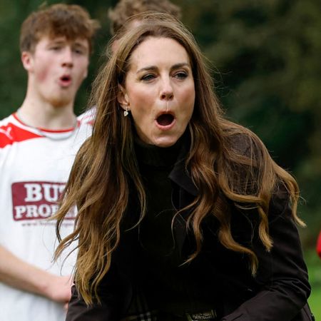 Princess Kate gasping with a shinty player standing behind her