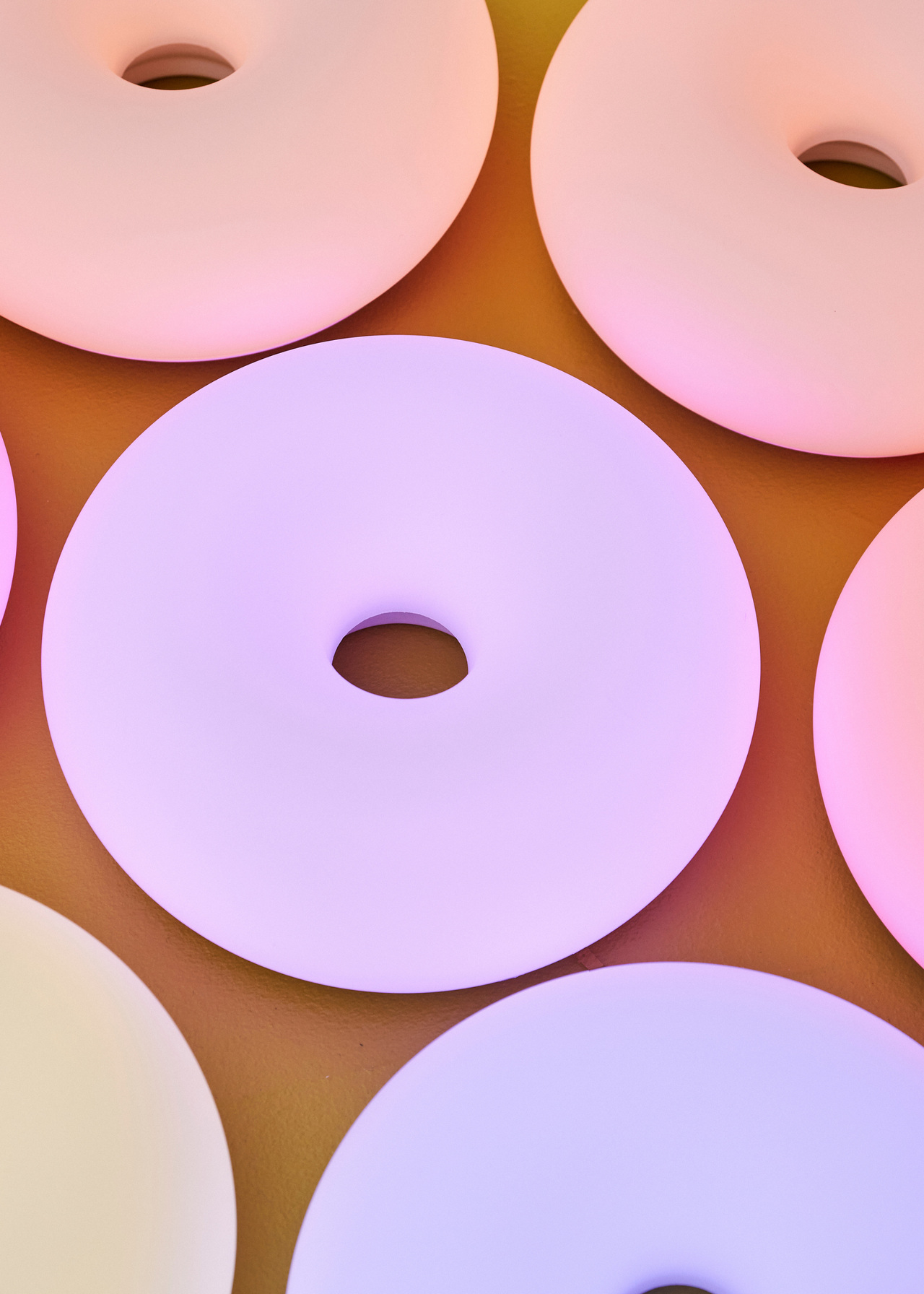 A yellow surface with many IKEA VARMBLIXT lamps in different colors