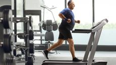 Man jogging on treadmill in gym