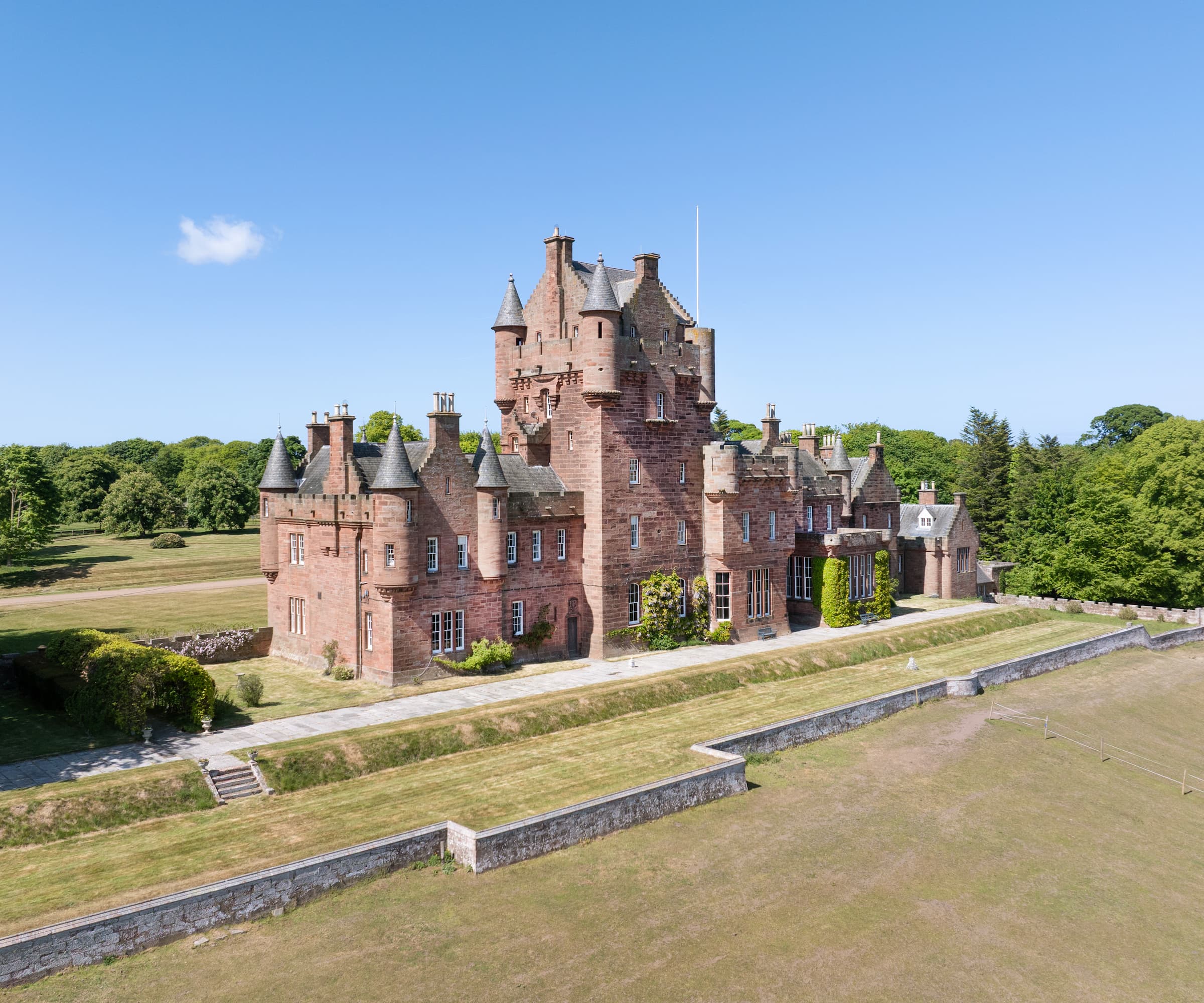 A red sandstone castle as seen from the garden