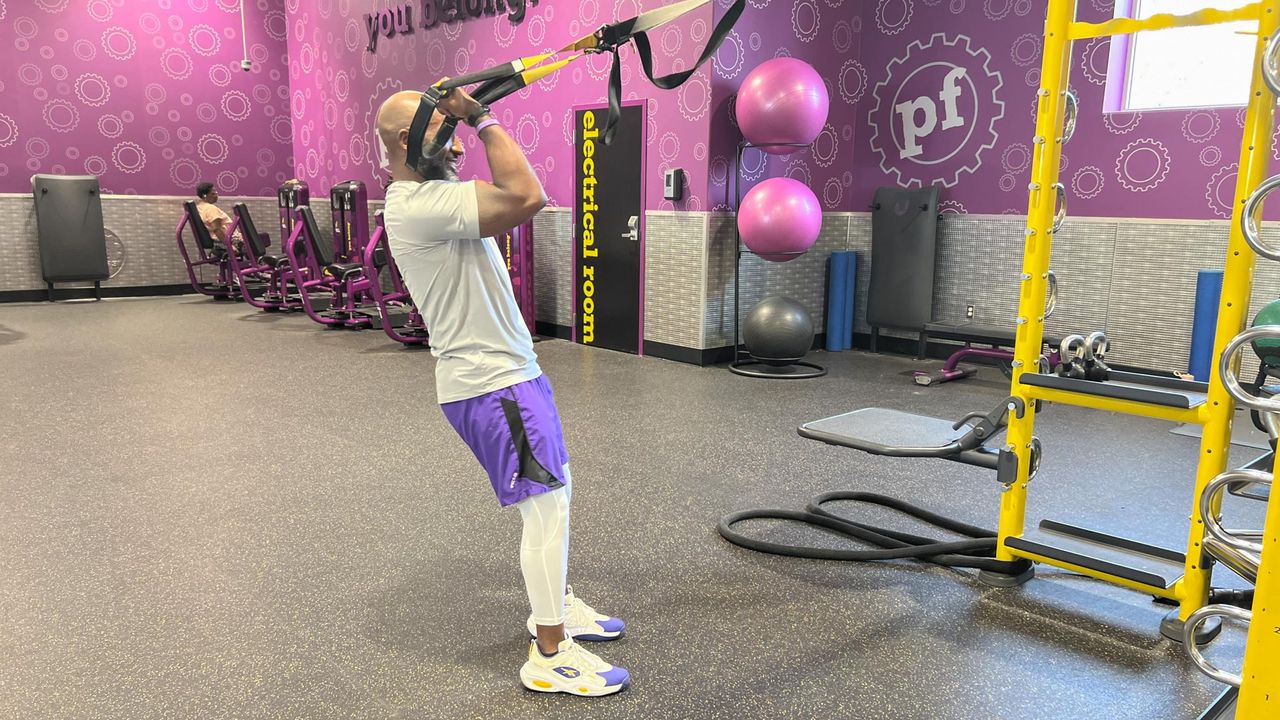Teddy Savage performing a TRX biceps curl