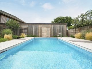 Weathered wood walls surrounding the garden pool