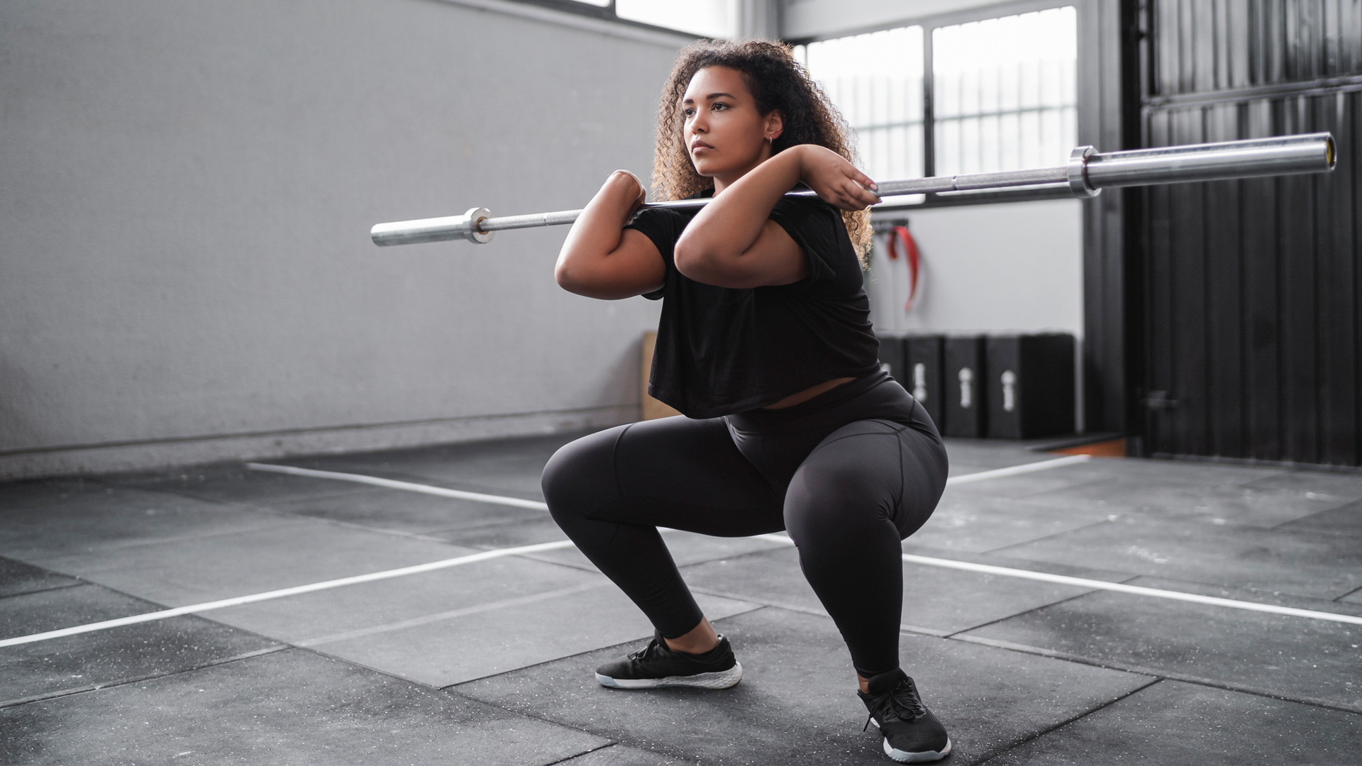 woman using a barbell to perform a front-loaded squat