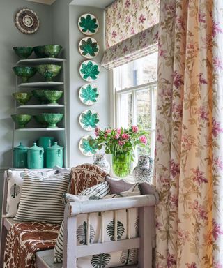 A collection of decorative paltes displayed in a window recess and Moroccan green glazed pottery on shelves