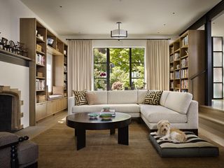 A living room with bookshelves that stretch to the ceiling