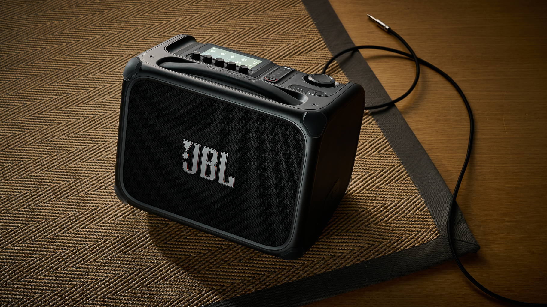 A JBL BandBox Trio guitar amp on a rug