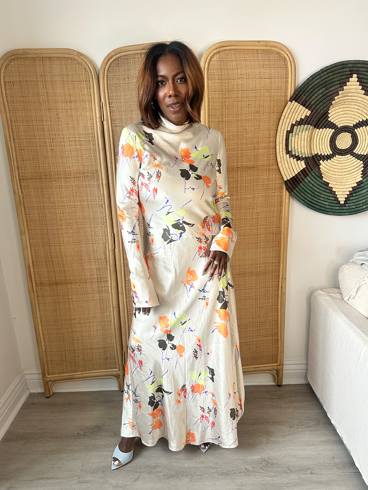 Who What Wear Editor in Residence Tiffany Reid wearing a maxi-length floral dress for a TV segment.