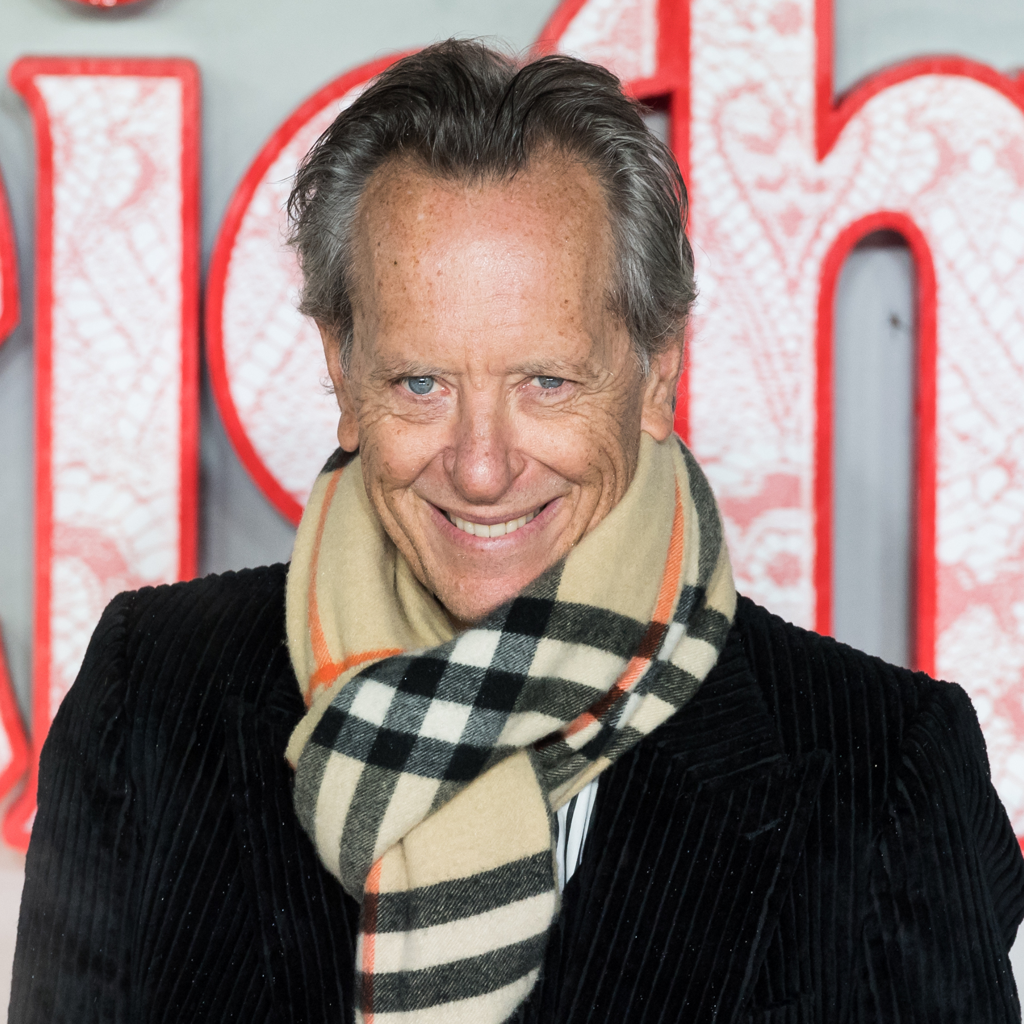 Richard E. Grant wearing trench coat and burberry scarf at Wuthering Heights premier.