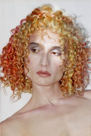 man wearing orange curly haired wig