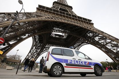 A police car in front of the Eiffel Tower.