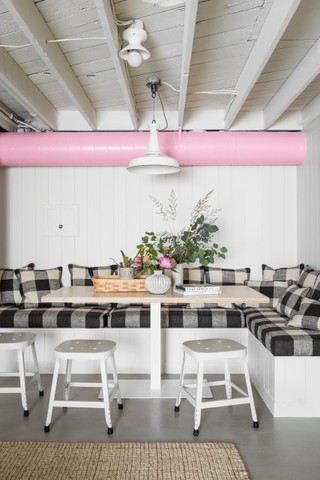 Dining nook with gingham seats and white panelled walls