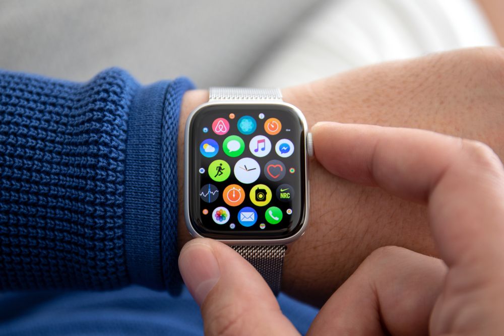 Image of an Apple Watch on a man&#039;s wrist with many different app icons on the watch screen