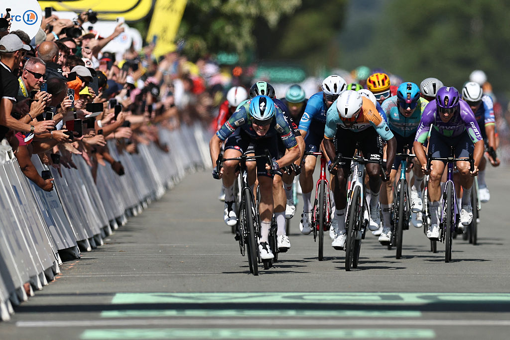 Soudal Quick-Step team's Belgian rider Tim Merlier (L) sprints to the finish line to win the 8th stage ahead of NSN Cycling Team's Eritrean rider Biniam Girmay (C) during the 113th edition of the Tour de France cycling race, 182km