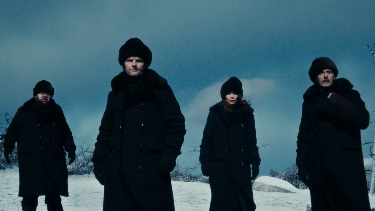 From left to right: Dylan, Mark, Helly and Irv standing outside in the snow in matching black coats and hats. 