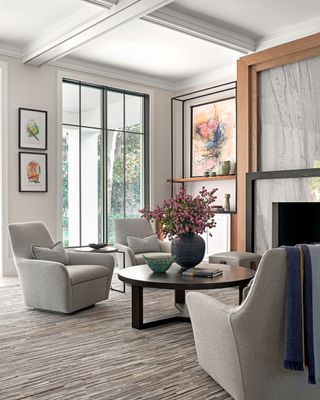 Living room with off-white easy chairs taupe marble fireplace