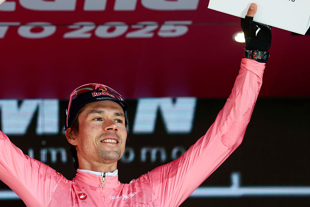 Red Bull-Bora-Hansgrohe's Slovenian rider Primoz Roglic wearing the overall leader's pink jersey (Maglia Rosa) celebrates on the podium after the second stage of the 108th Giro d'Italia cycling race, a 13.7km individual time-trial from Tirana to Tirana in Albania, on May 10, 2025. (Photo by Luca Bettini / AFP)