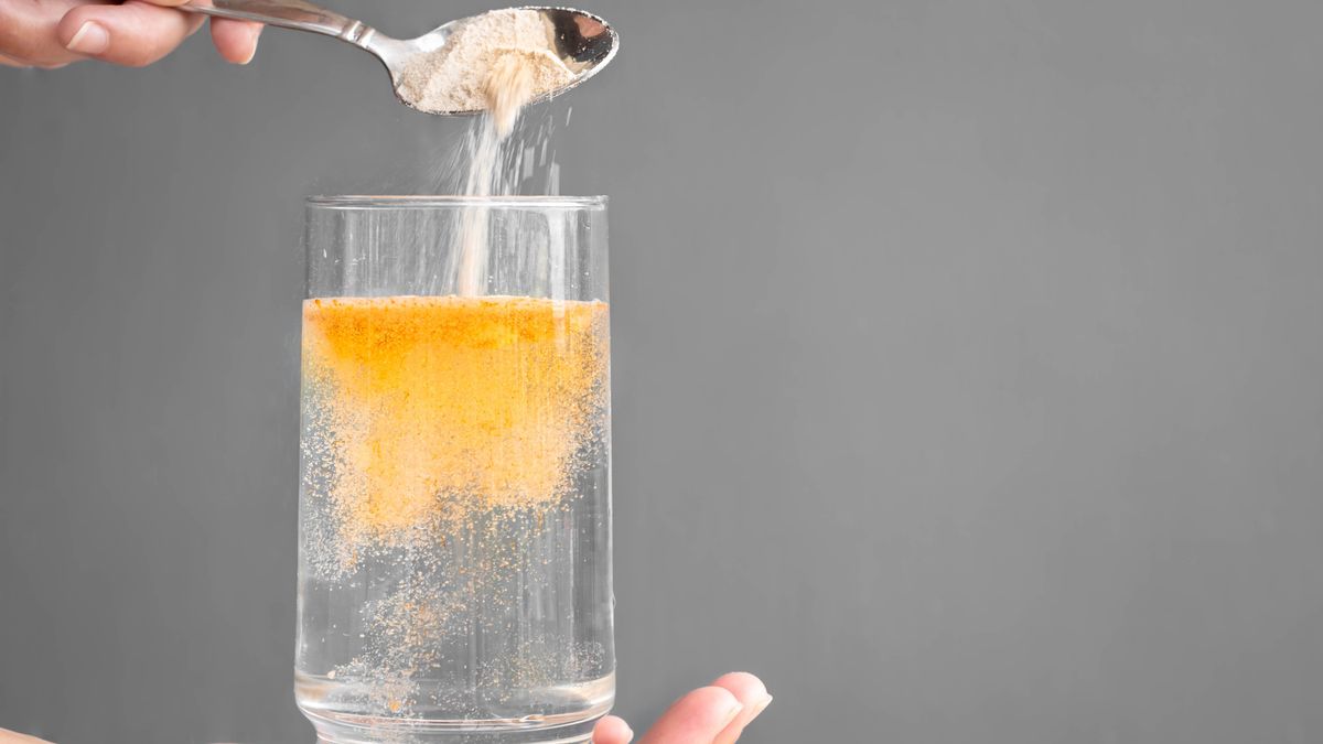 Orange fizzy powder and water glass with copy space