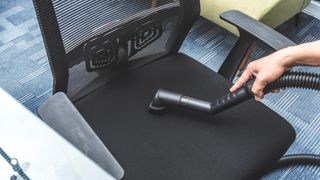 A vacuum cleaning an office chair