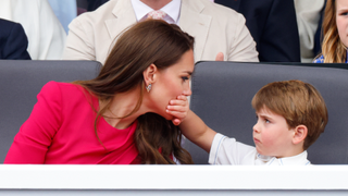 Prince Louis of Cambridge covers his mother Catherine, Duchess of Cambridge's mouth with his hand as they attend the Platinum Pageant on The Mall on June 5, 2022 in London, England
