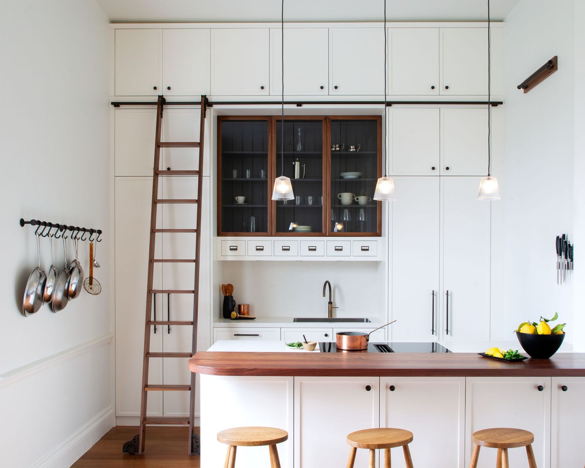 A white kitchen with a wooden kitchen ladder